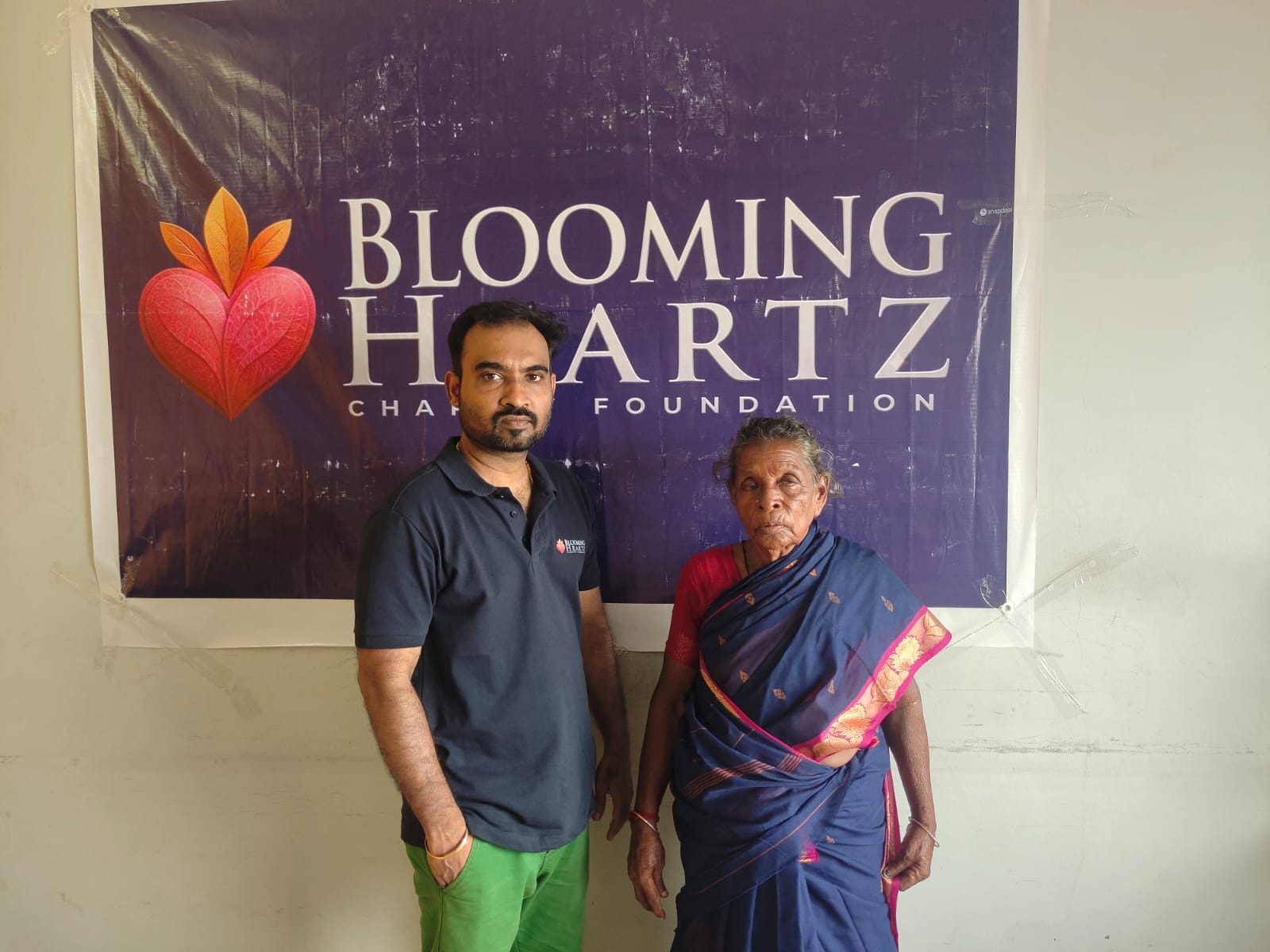 Pattu paati smiling in her new blue saree after changing at the shelter